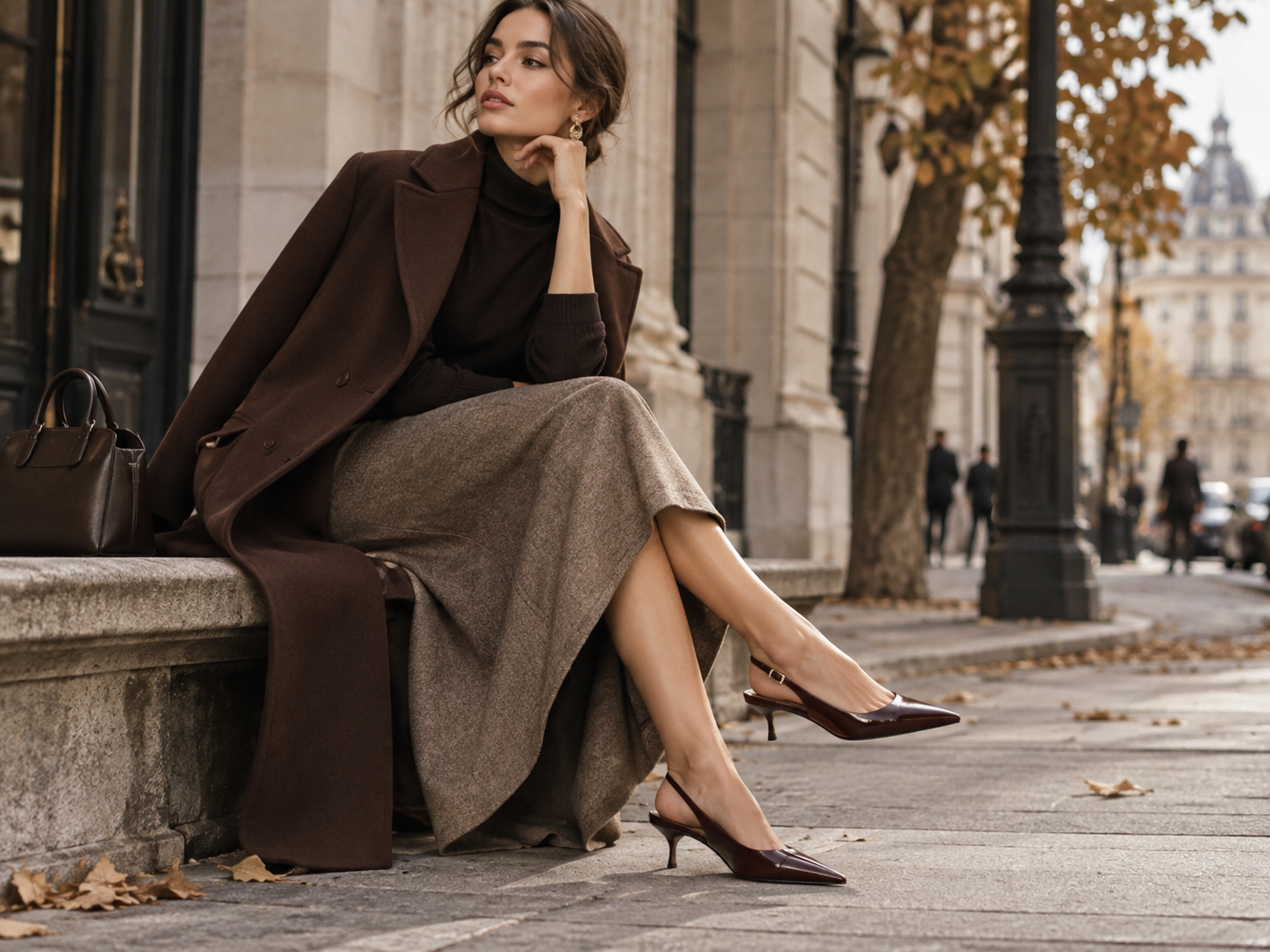 Elegantan ženski outfit sa slingback cipelama niskom petom midi suknjom i smeđim kaputom